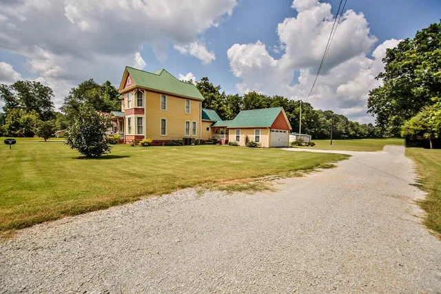 a view of a house with a swimming pool and a yard
