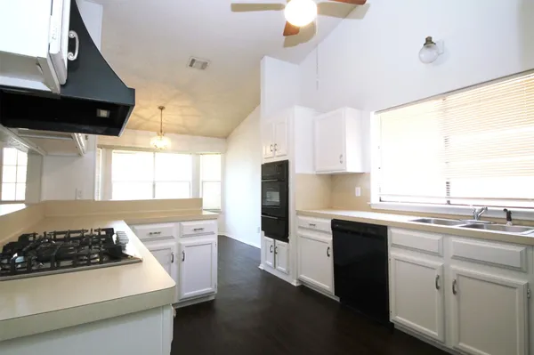 a kitchen with a sink a stove and cabinets
