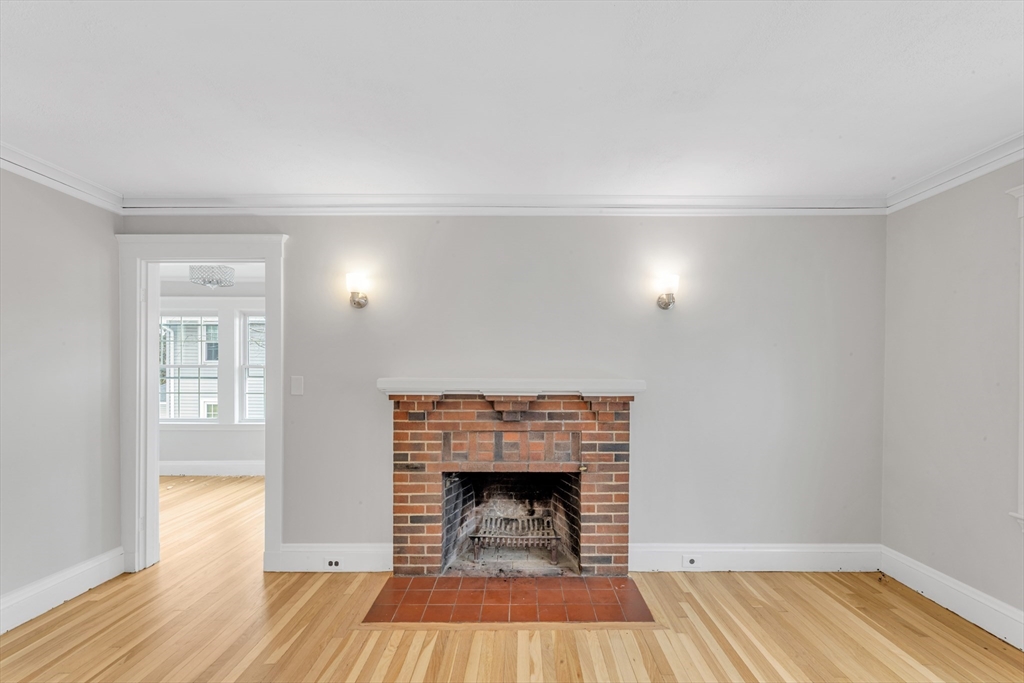 21-23 Richards Road, Unit 21 Watertown, MA 02472 - Photo 13 of 28 a room with a fireplace and wooden floor