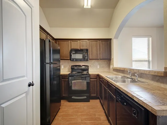 a kitchen with a sink stove and refrigerator