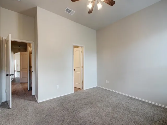 an empty room with a empty space and a ceiling fan