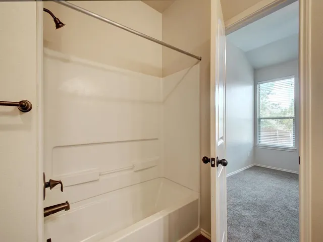 a bathroom with a bath tub with a shower