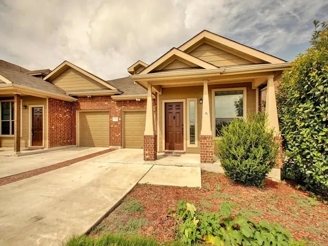 a view of a house with a small yard and plants