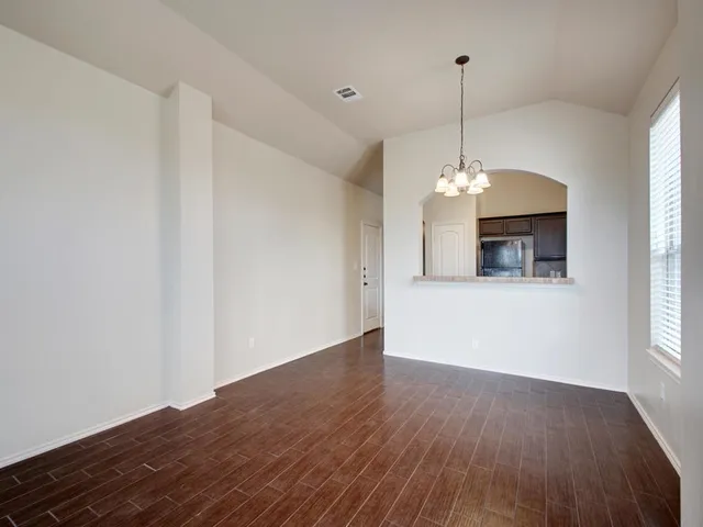 a view of a room with window wooden floor and chandelier