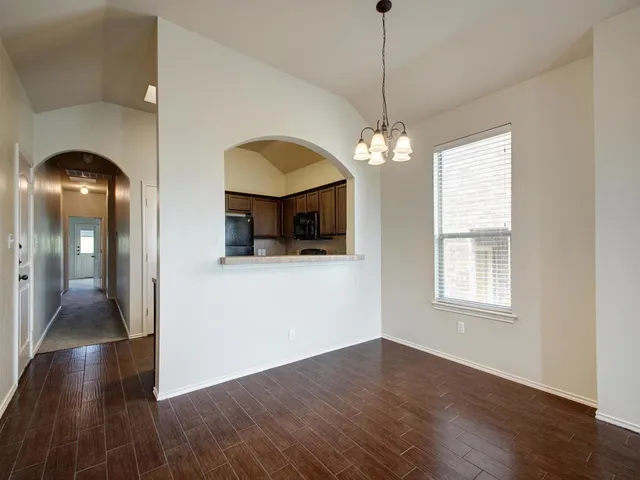 a view of a livingroom with wooden floor a ceiling fan and window
