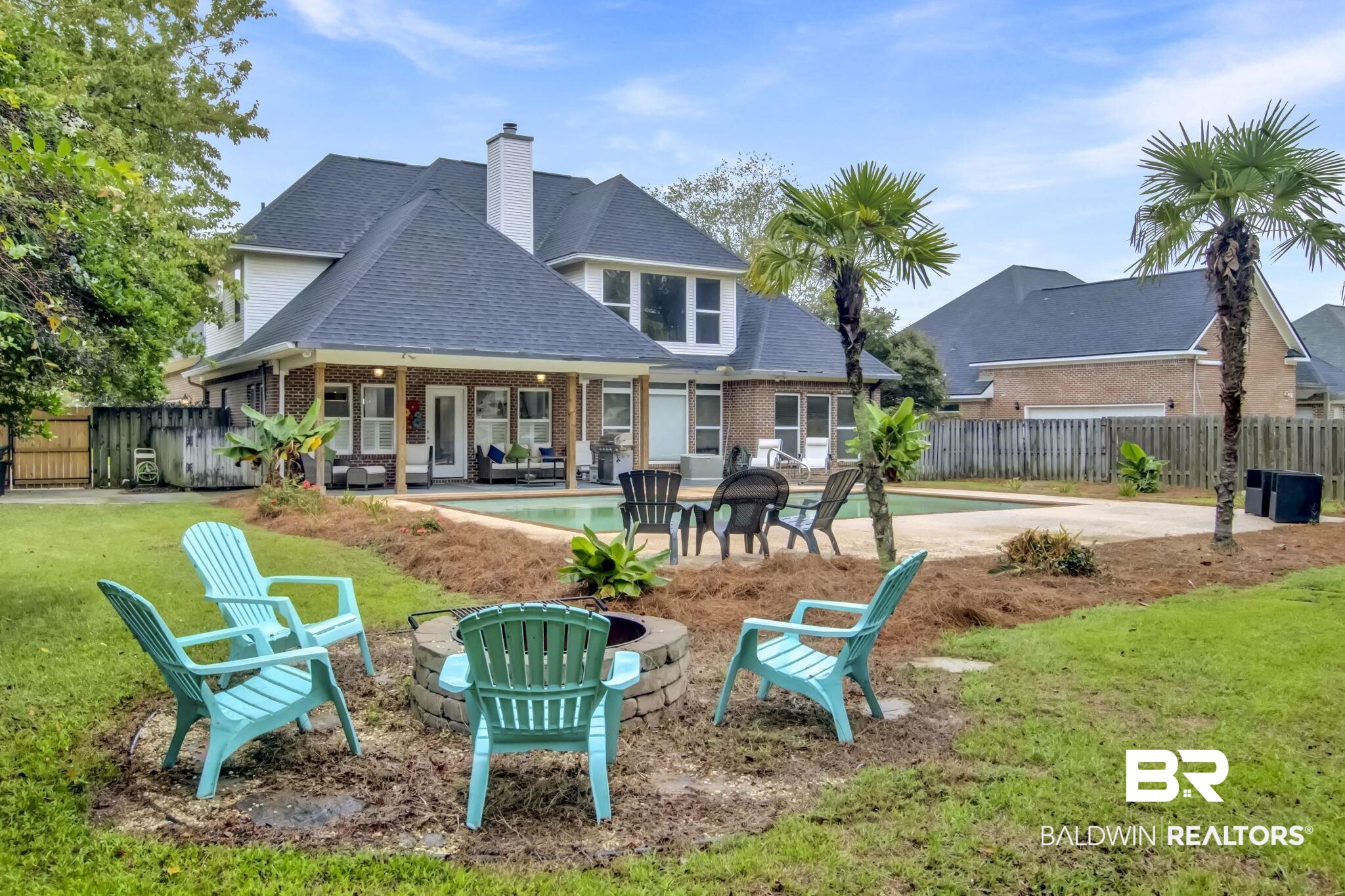 9002 Parliament Circle Daphne, AL 36526 - Photo 61 of 73 Rear view of house featuring a yard, a fenced in pool, and a patio area, fire pit area.