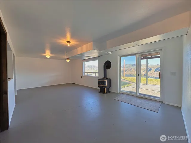 an empty room with a window and chandelier