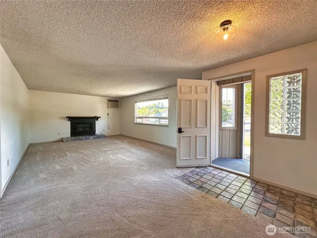 an empty room with a window and a kitchen