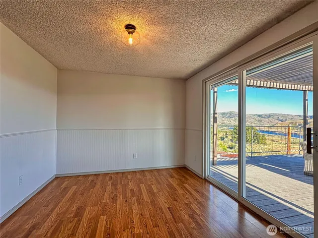 a kitchen with stainless steel appliances granite countertop a refrigerator a sink dishwasher a stove and white countertops with wooden floor