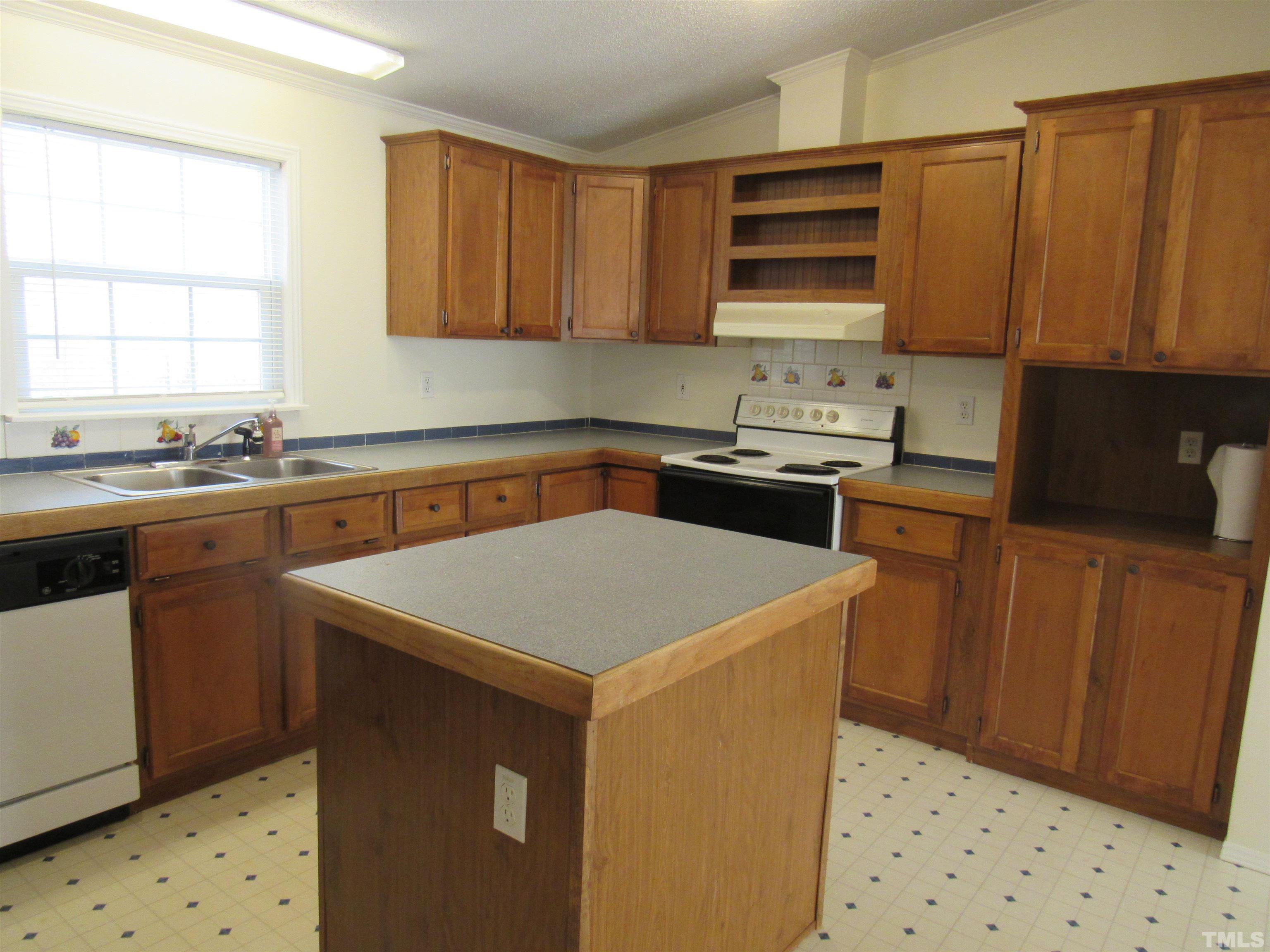 7816 Huff Farm Road Willow Spring, NC 27592 - Photo 6 of 25 a kitchen with a sink a stove and cabinets