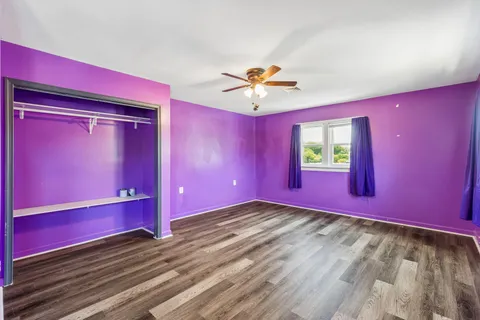 a view of a livingroom with a red fan and wooden floor