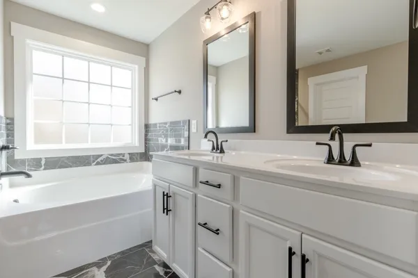 a bathroom with a tub sink and mirror