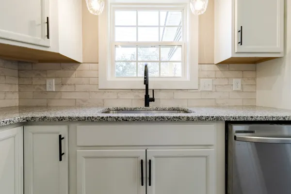 a kitchen with granite countertop a sink and a window
