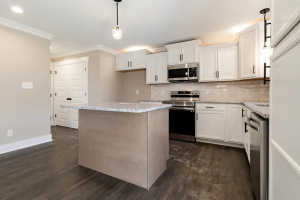 a kitchen with stainless steel appliances granite countertop a stove a sink and a refrigerator