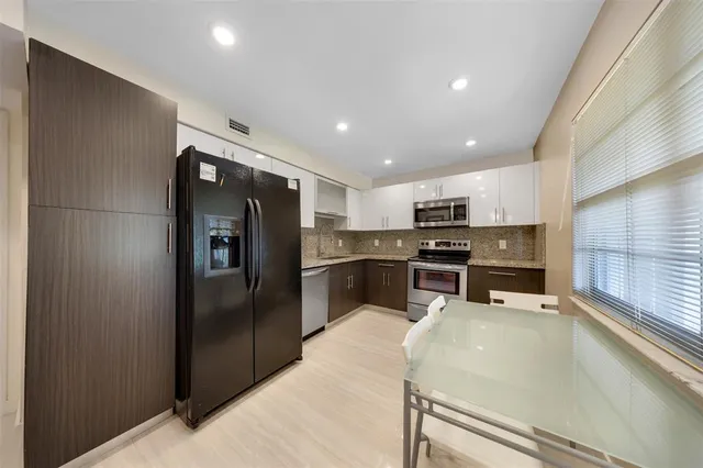 a kitchen with stainless steel appliances granite countertop a refrigerator and a stove top oven