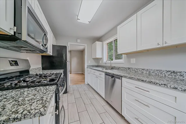 a kitchen with stainless steel appliances granite countertop a stove and a sink