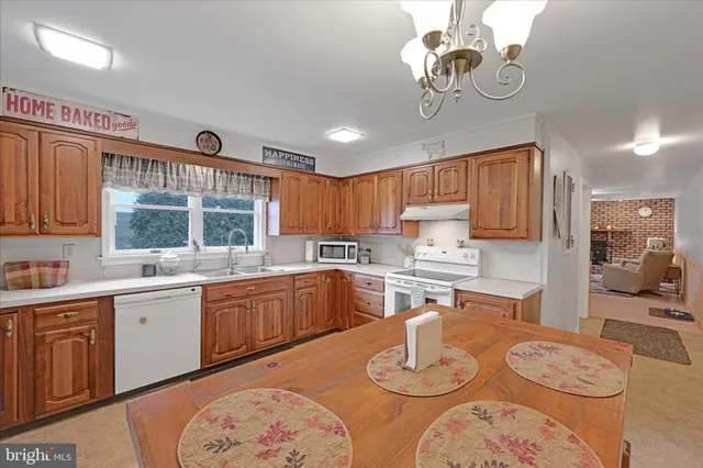 a kitchen with stainless steel appliances granite countertop a sink dishwasher stove and refrigerator with wooden floor