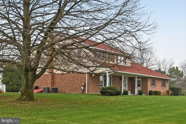 a front view of a house with a garden and trees