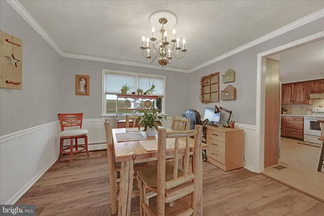 a view of a dining room with furniture and chandelier