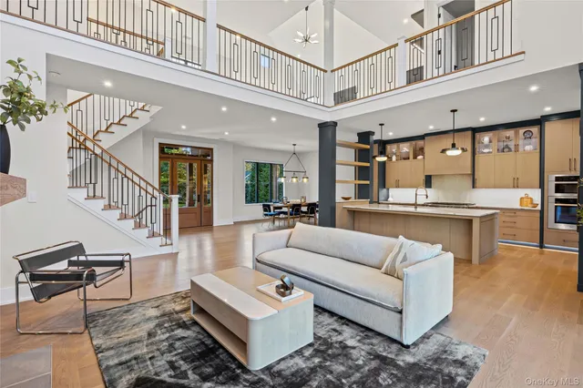 a living room with furniture and kitchen view with wooden floor