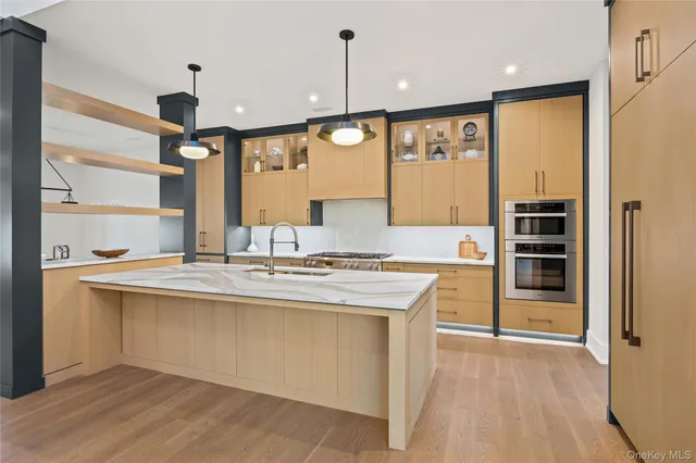 a kitchen with kitchen island a sink stainless steel appliances and cabinets