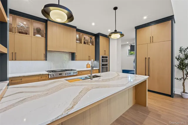 a kitchen with stainless steel appliances granite countertop a sink a refrigerator and a stove