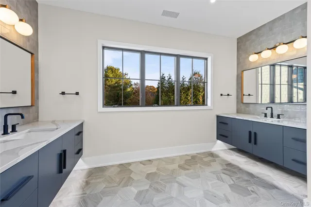 a spacious bathroom with a tub sink and mirror