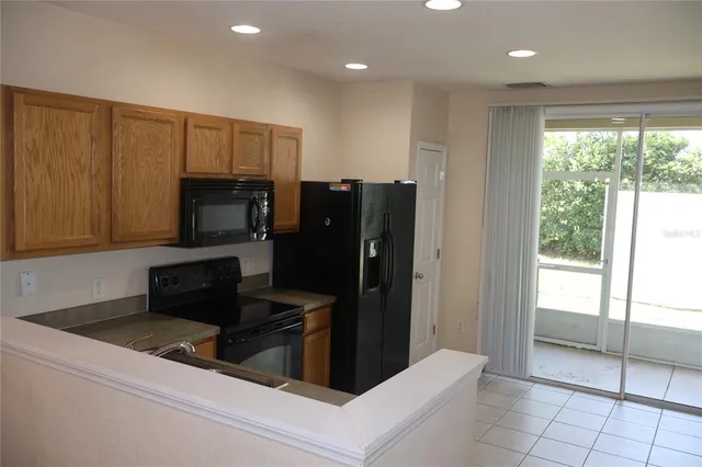 a kitchen with granite countertop a refrigerator and a sink