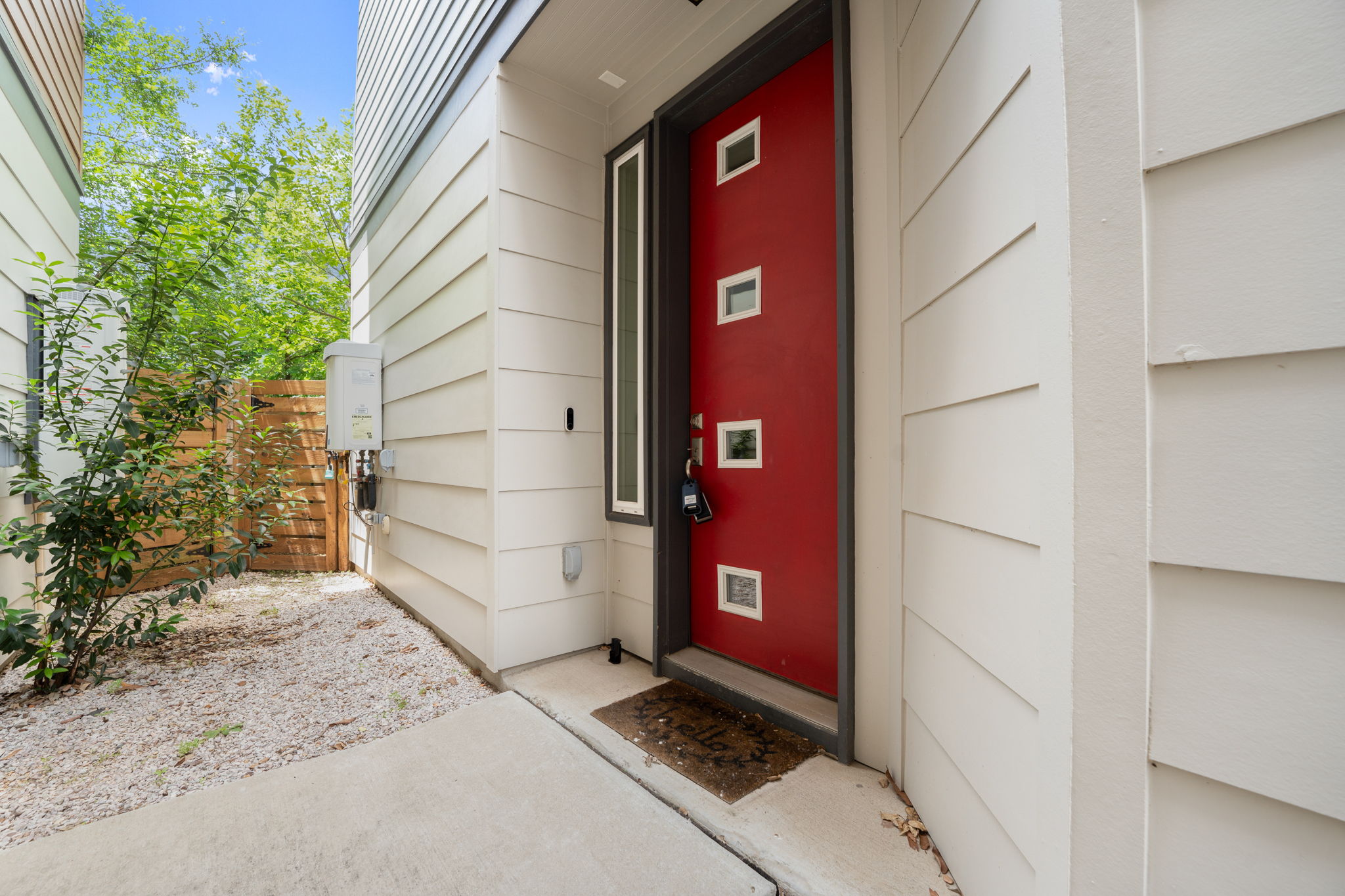 4403 Swift Path Austin, TX 78741 - Photo 27 of 32 Modern red entry door with square window inserts, complemented by a vertical sidelight