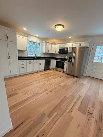 a view of kitchen with refrigerator and microwave