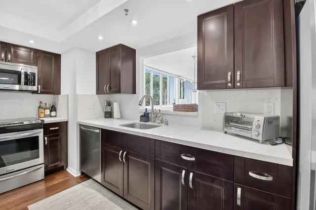 a kitchen with stainless steel appliances a stove microwave and sink