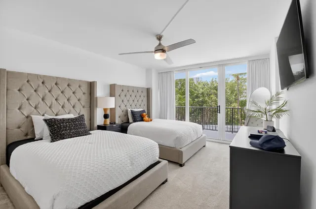 a spacious bedroom with a bed flat screen tv and a large window