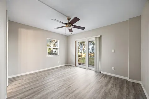 a view of an empty room with window and wooden floor