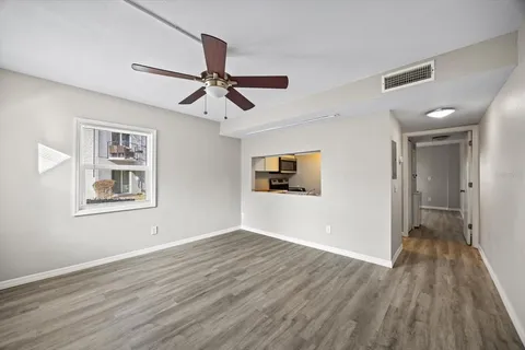 a view of a big room with wooden floor and windows