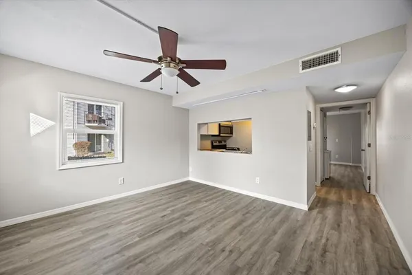 a view of a big room with wooden floor and windows