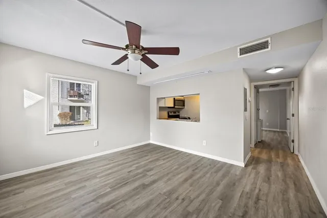 a view of a big room with wooden floor and windows