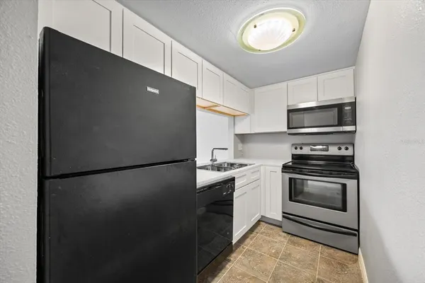 a kitchen with a refrigerator and a stove