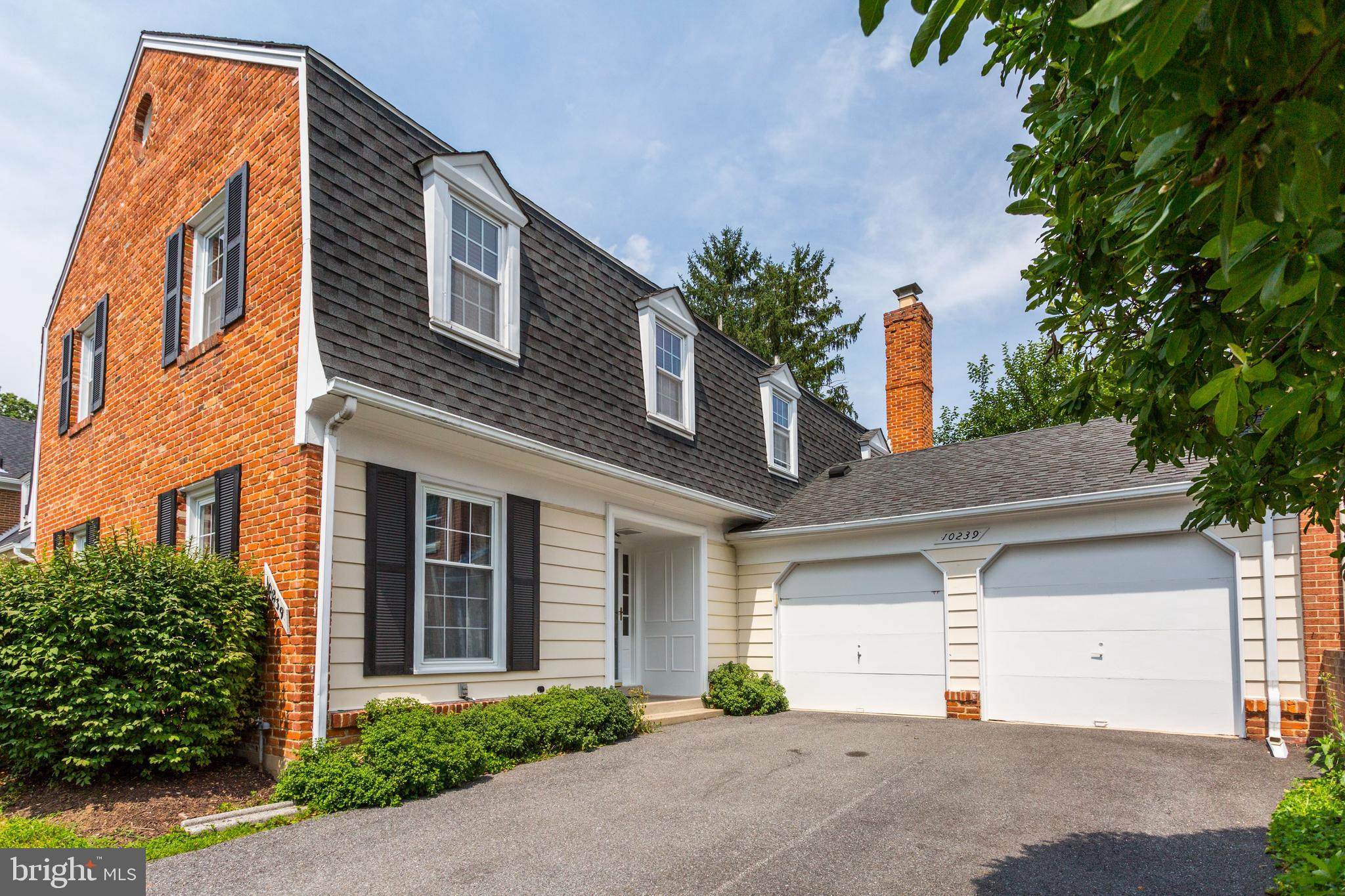 10239 Gainsborough Road Potomac, MD 20854 - Photo 1 of 21 a front view of a house with a yard and garage