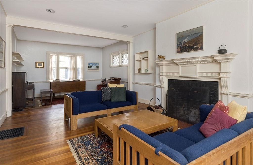 63 Griggs Road Brookline, MA 02446 - Photo 3 of 12 a living room with furniture a flat screen tv and a fireplace
