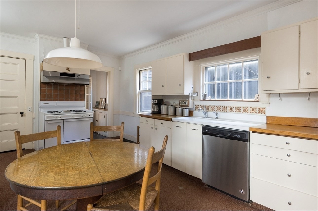 63 Griggs Road Brookline, MA 02446 - Photo 6 of 12 a kitchen with stainless steel appliances a stove a sink dishwasher and a refrigerator with wooden floor