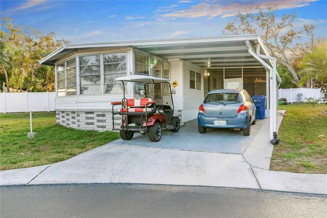 a view of a house with a cars park next to a yard