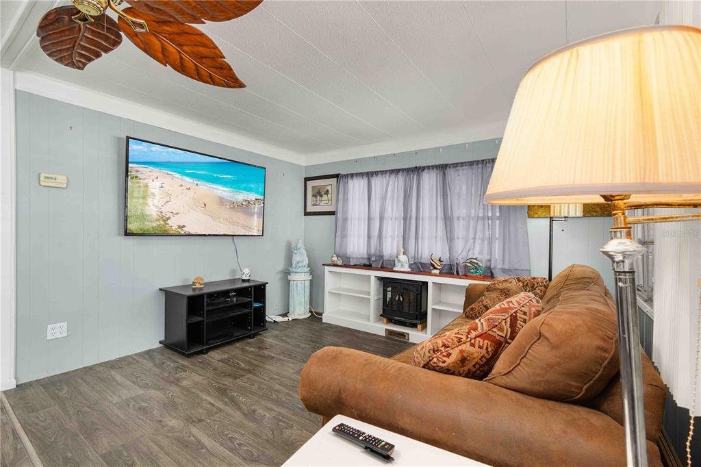 10399 67th Avenue North, Unit 4 St. Petersburg, FL 33708 - Photo 13 of 35 a living room with furniture a window and a flat screen tv