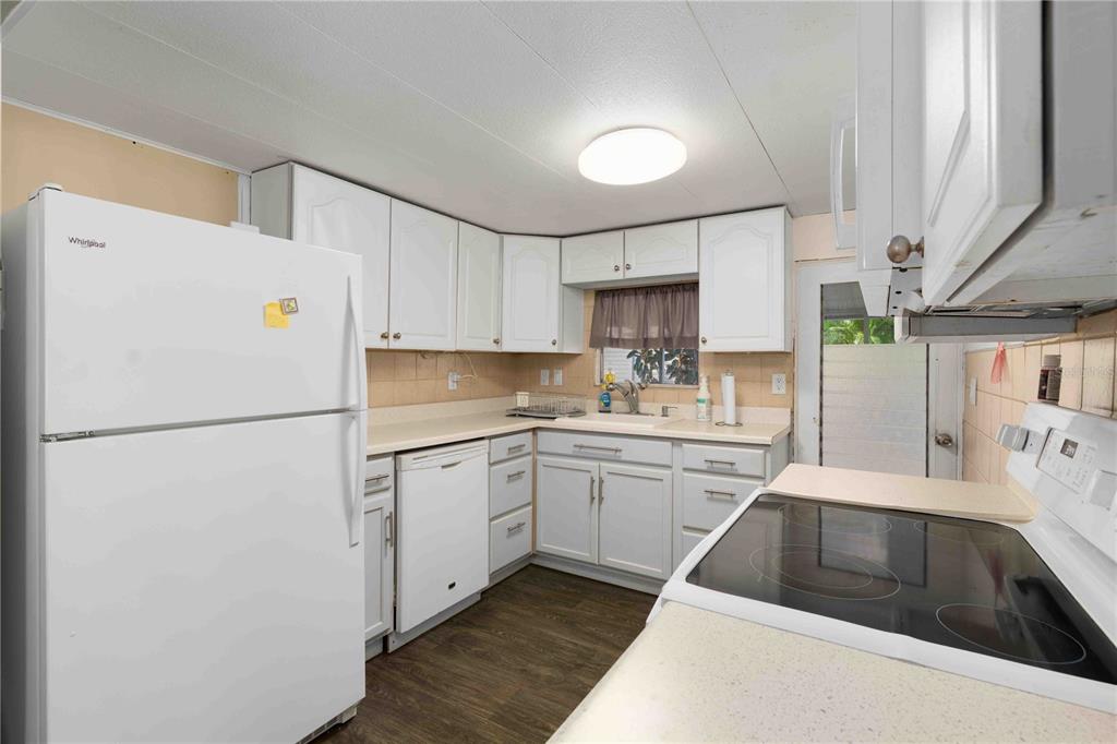 10399 67th Avenue North, Unit 4 St. Petersburg, FL 33708 - Photo 6 of 35 a kitchen with a white cabinets and white appliances