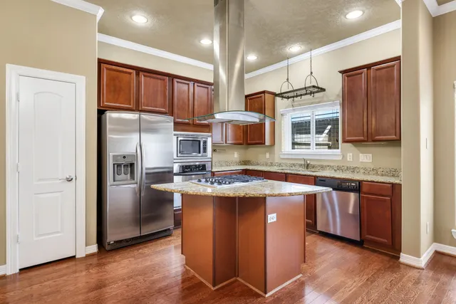 a kitchen with stainless steel appliances granite countertop a refrigerator a stove top oven a sink and dishwasher