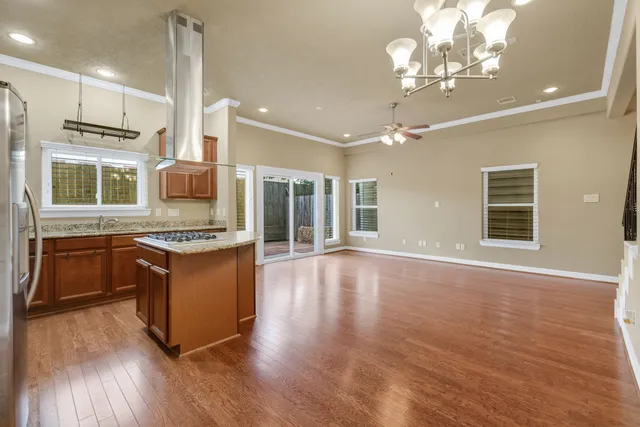 a large kitchen with stainless steel appliances granite countertop a oven a stove and a wooden floors
