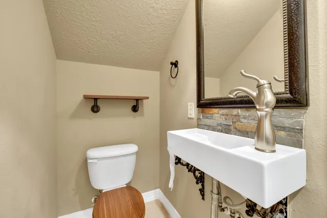 a bathroom with a sink a toilet and mirror
