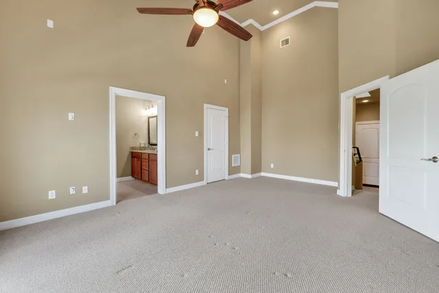 a view of a room with a ceiling fan and entryway