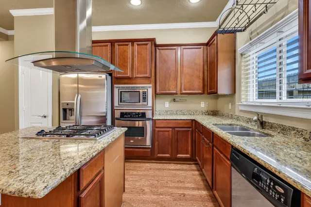 a kitchen with stainless steel appliances granite countertop a sink stove and cabinets