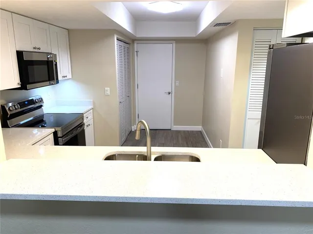 a kitchen with appliances a sink and cabinets
