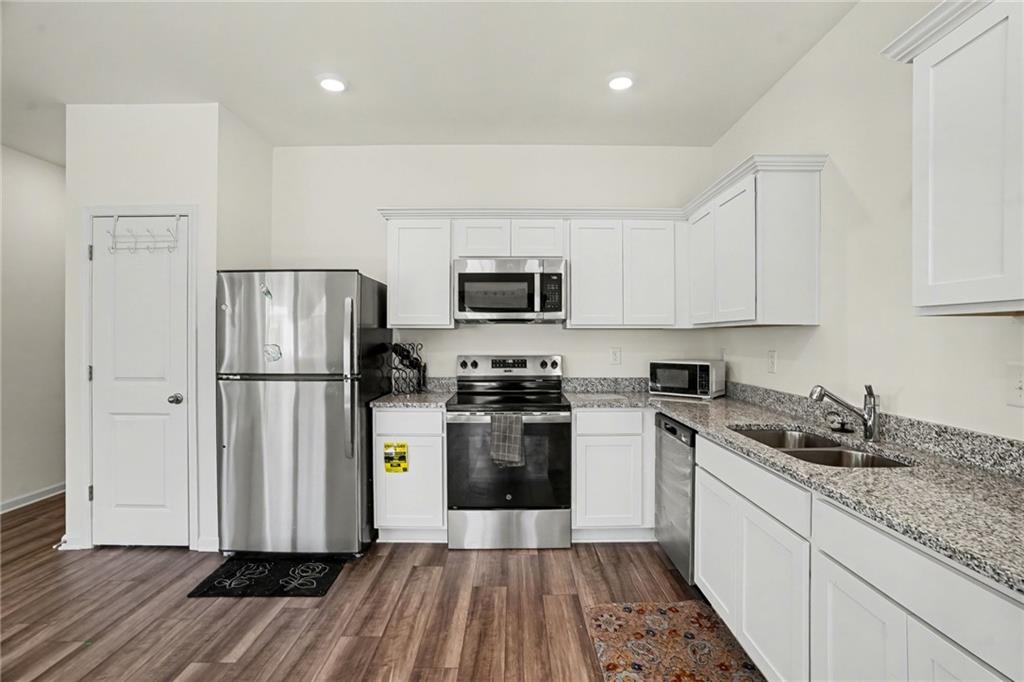 625 Jervis Way Locust Grove, GA 30248 - Photo 11 of 28 a kitchen with a sink a refrigerator and cabinets